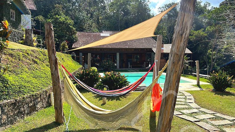 Refúgio com piscina, lareira e vista para o jardim