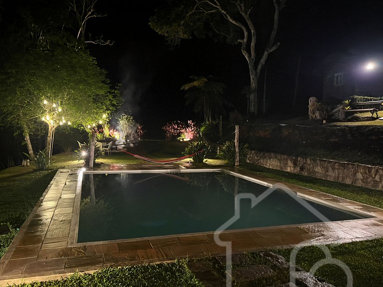 Refúgio com piscina, lareira e vista para o jardim